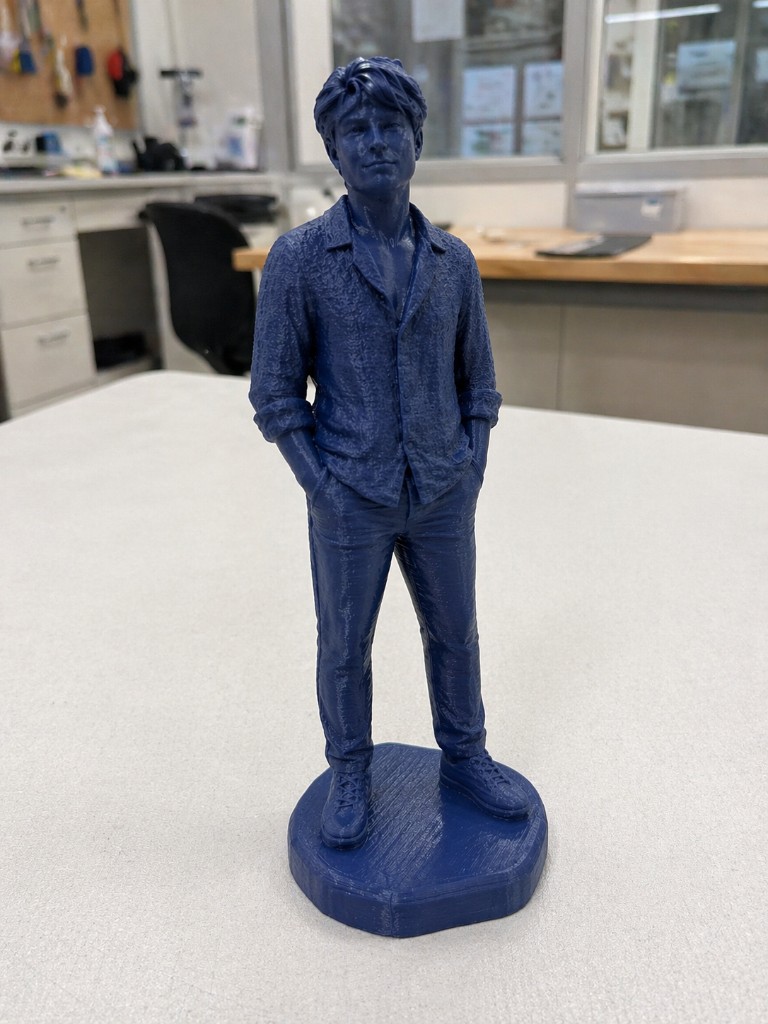 A 3D printed blue statue of Constantin on a workshop table